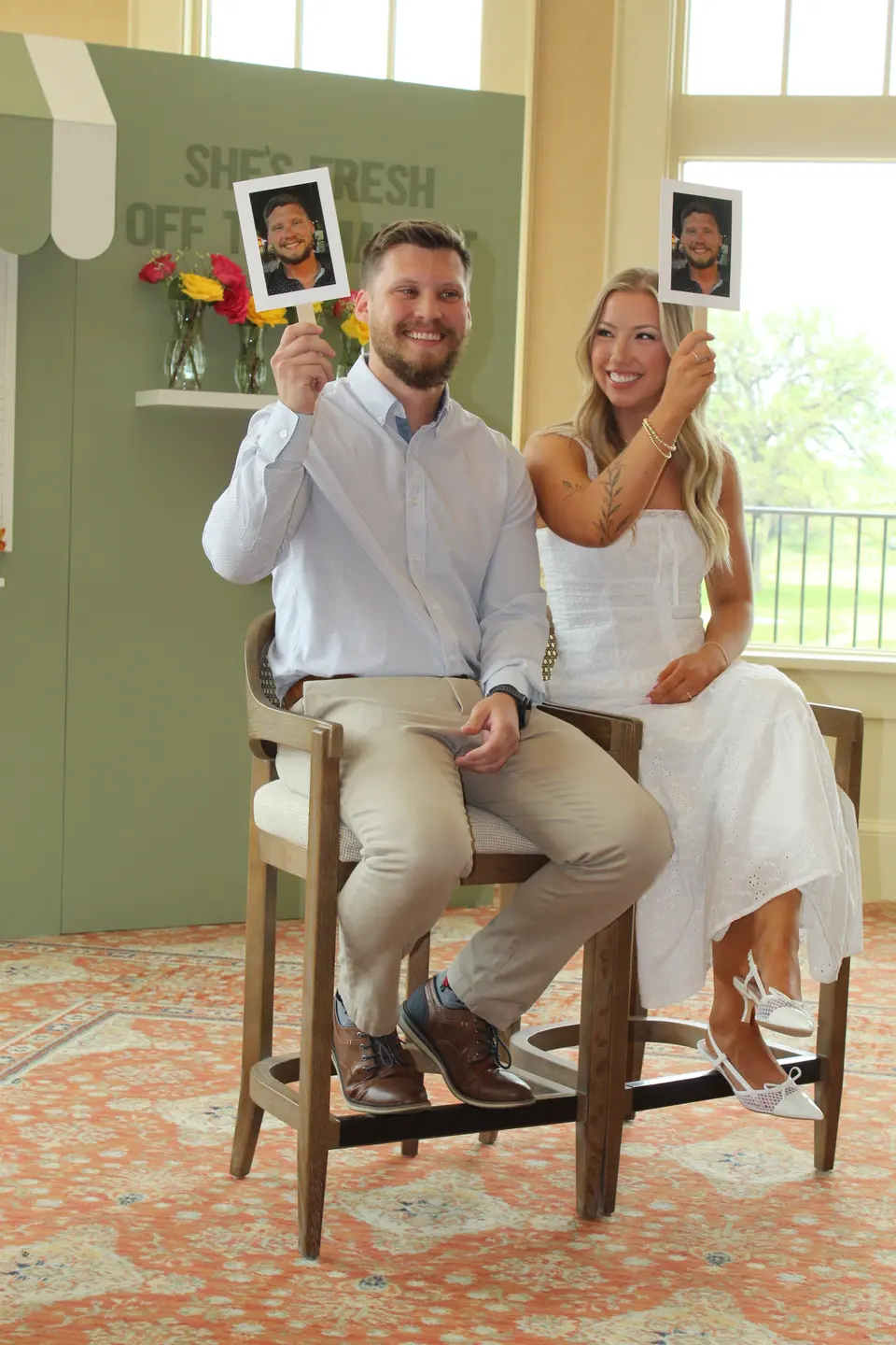 An engaged couple smiling while playing a photo-card game at their bridal shower