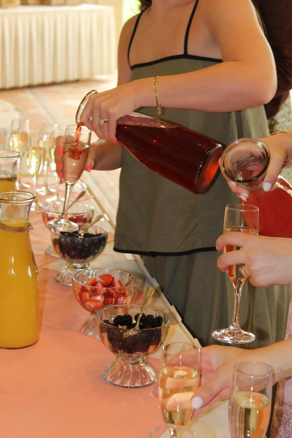 Guests pouring fruit drinks into champagne glasses at a bridal shower